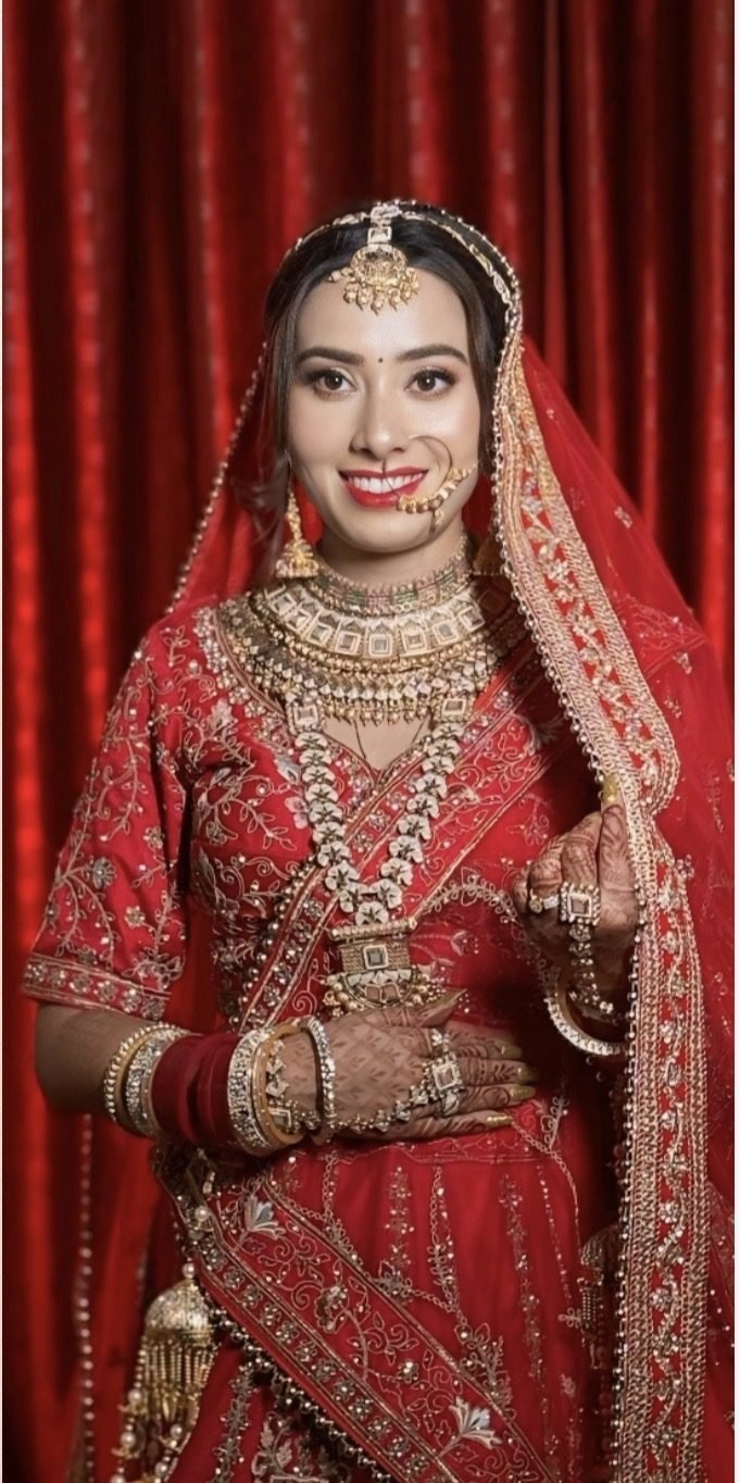 Bridal makeup by Priya Gupta, bride in a red lehenga